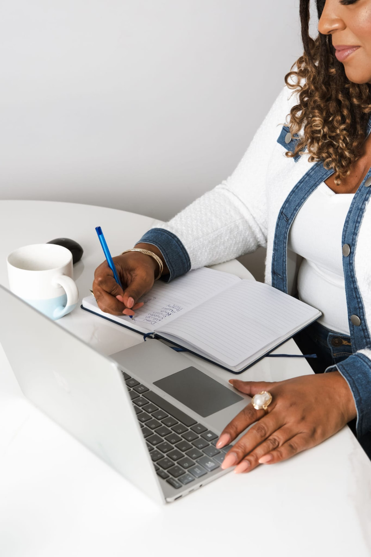 Jennifer Beckford making notes beside a laptop
