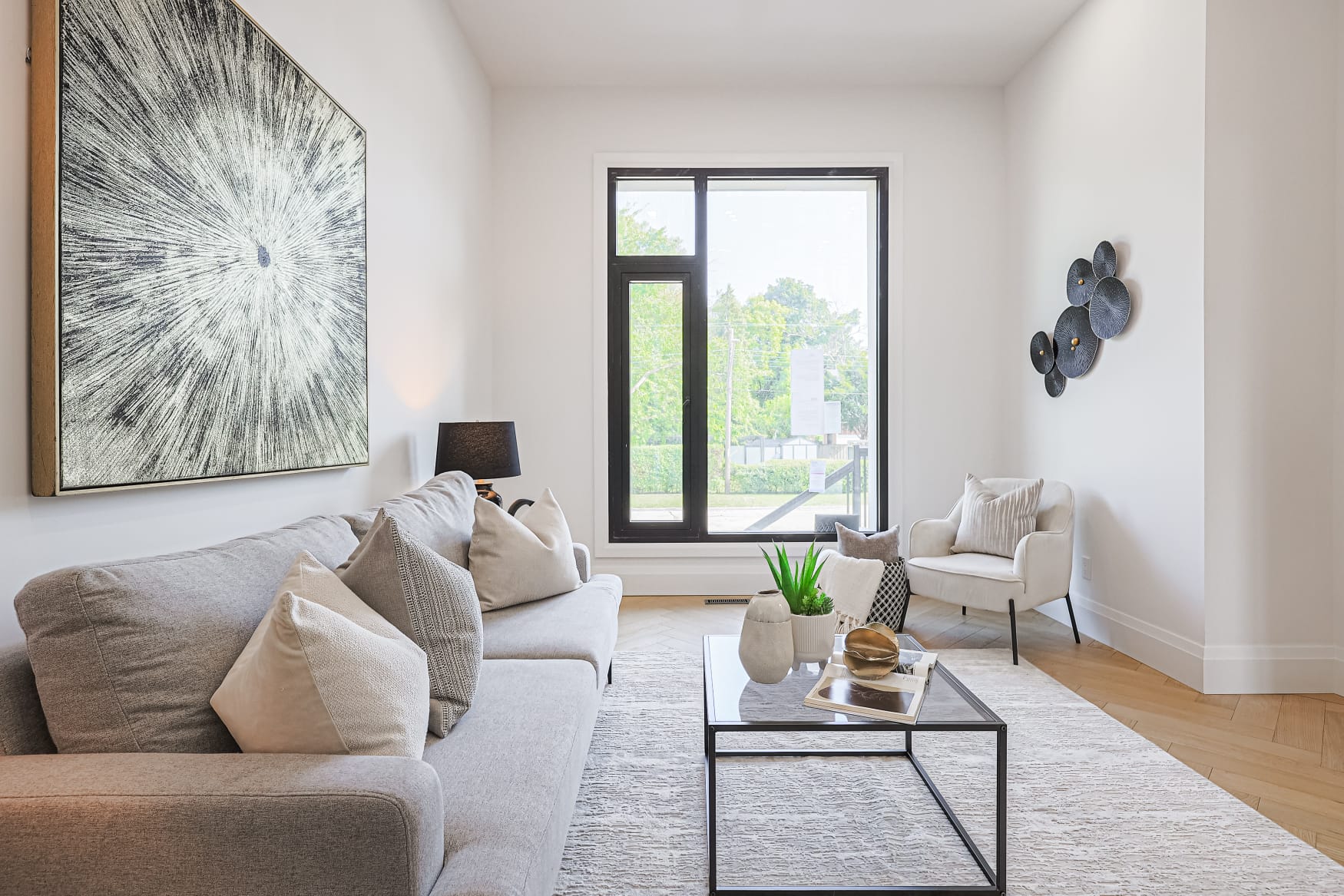 Sitting room with oversized starburst artwork and linen sofa